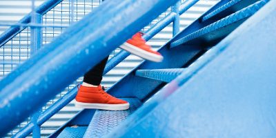 red shoes walking up blue metal stairs
