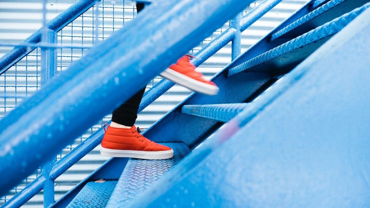 red shoes walking up blue metal stairs
